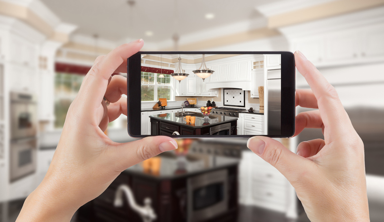 A person capturing a kitchen scene with a camera, focusing on the details and ambiance.